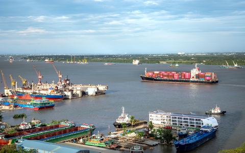 Aerial view of a busy cargo port with container ships and cranes
