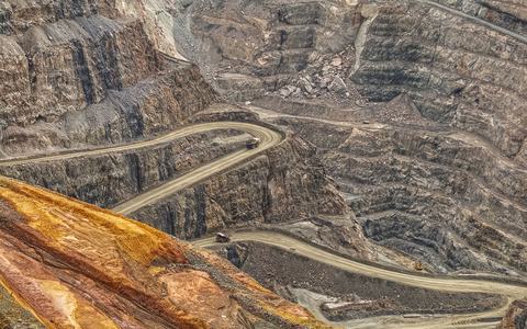 Aerial view of winding haul roads cut into the terraces of an open-pit mine