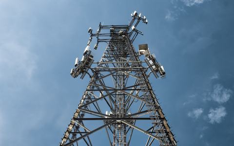 Low-angle view of a lattice telecom tower carrying mobile network antennas