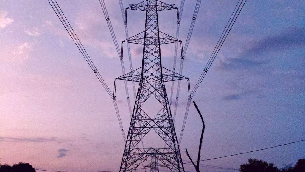 High-voltage power transmission tower and lines against a blue sky